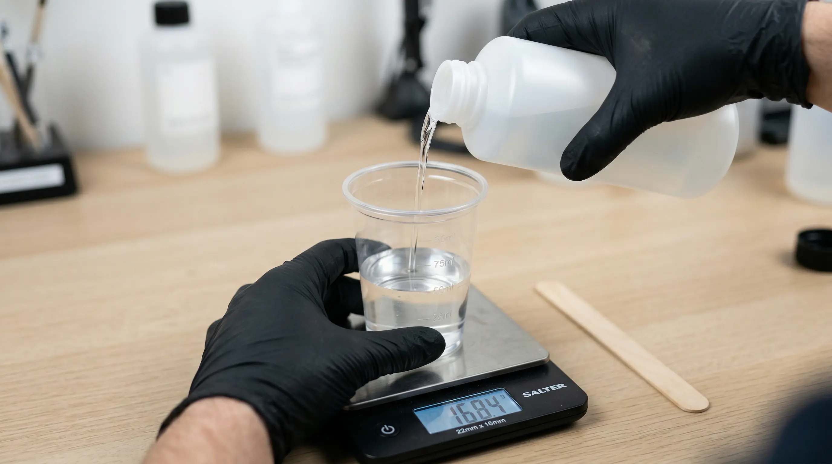 Mélange de résine époxy bicomposante sur balance de précision avec gants de protection